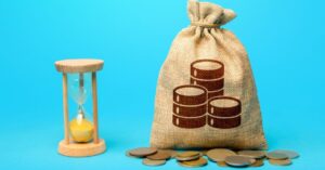 sack of coins next to a sand clock