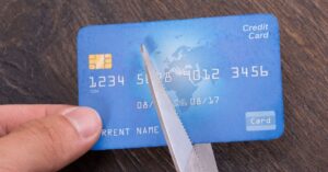 (using scissors to cut a credit card in half)
