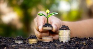 (piles of coins with soil and a flourishing plant on them indicating cash flow)