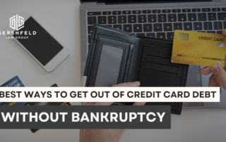 Person holding a credit card over an empty wallet and laptop, representing the struggle with debt and the search for non-bankruptcy solutions.